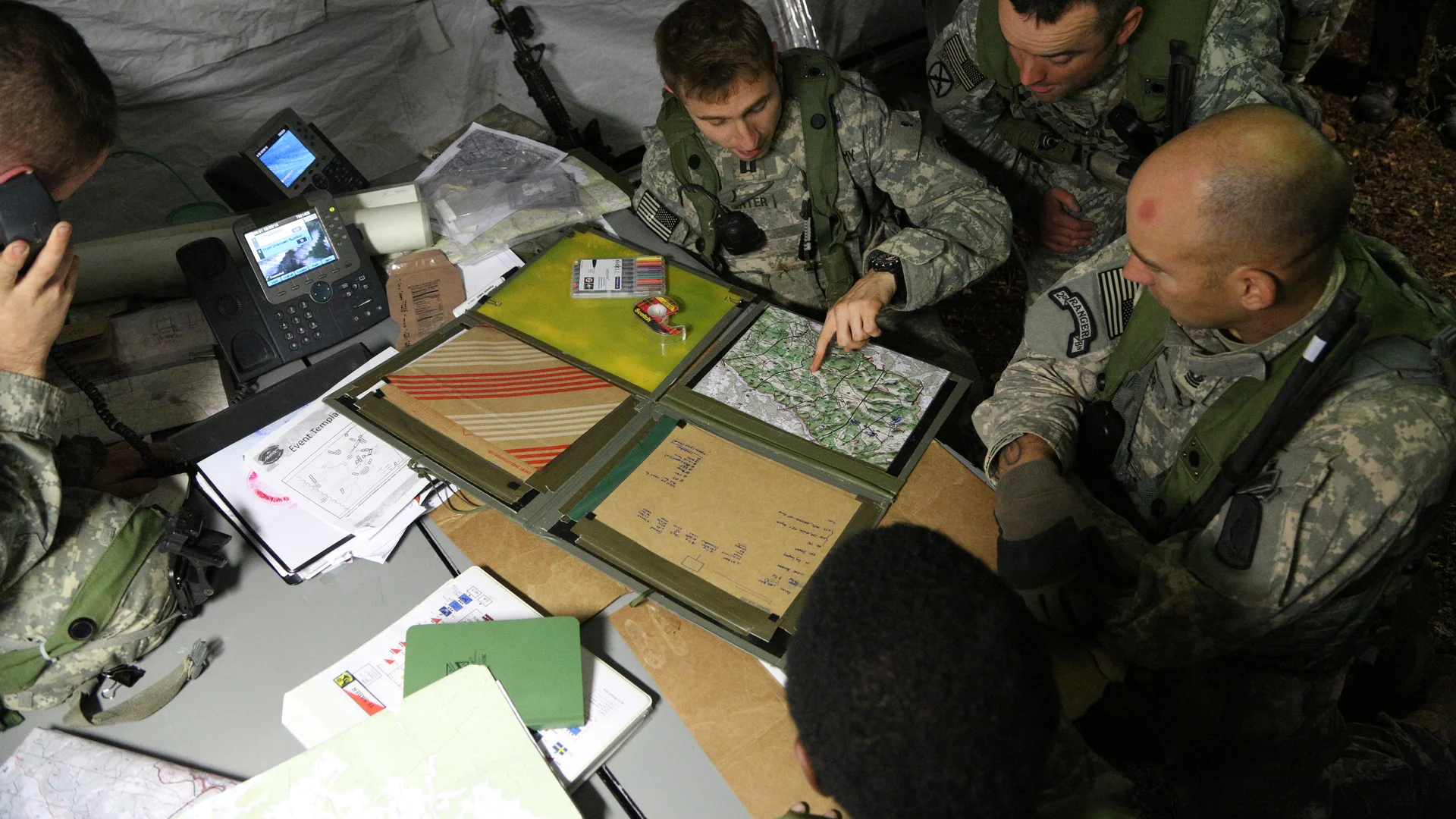 U.S. Army soldiers study a map in a tactical operations center during a 2014 exercise