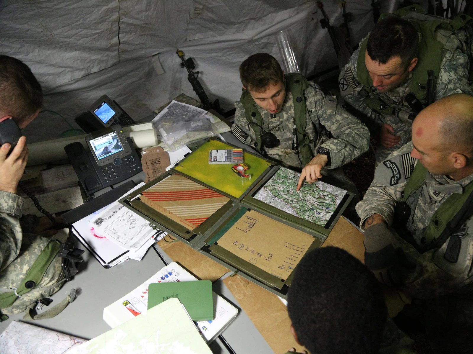 U.S. Army soldiers study a map in a tactical operations center during a 2014 exercise