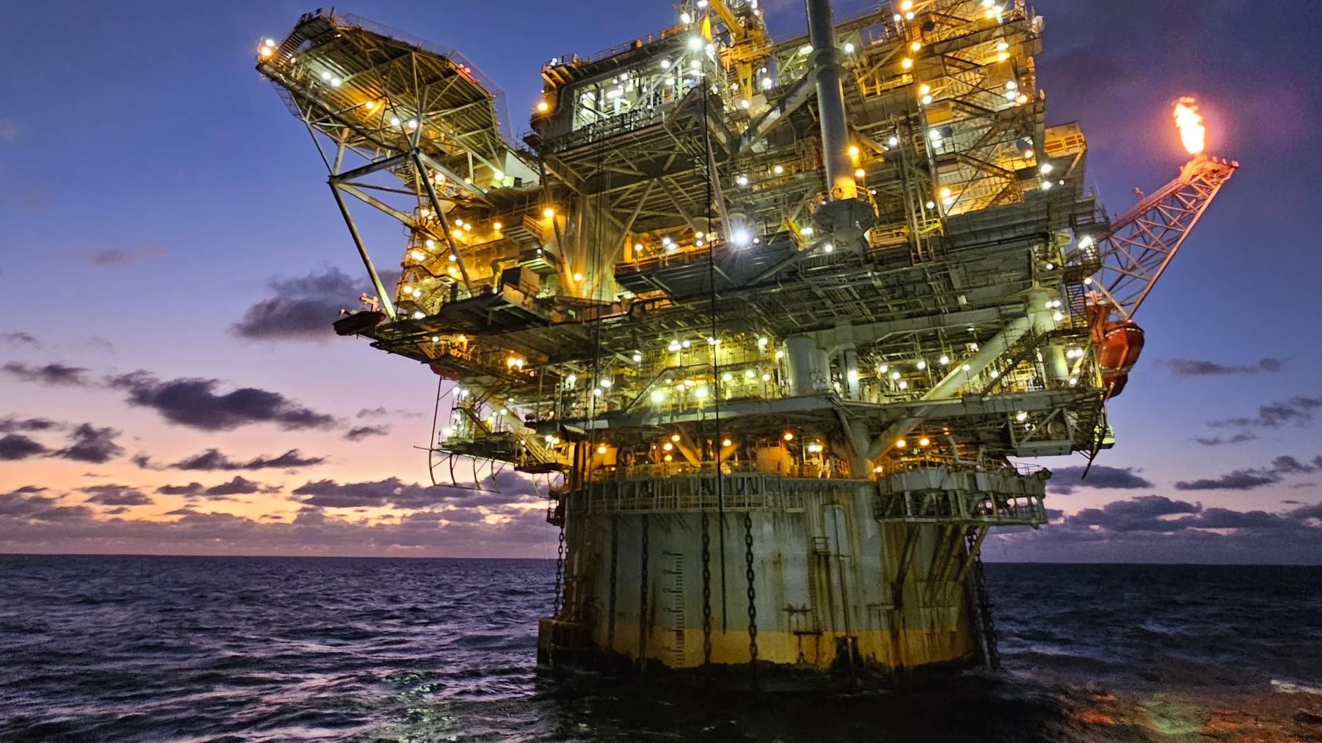 Holstein offshore oil platform illuminated at dusk in the Gulf of Mexico