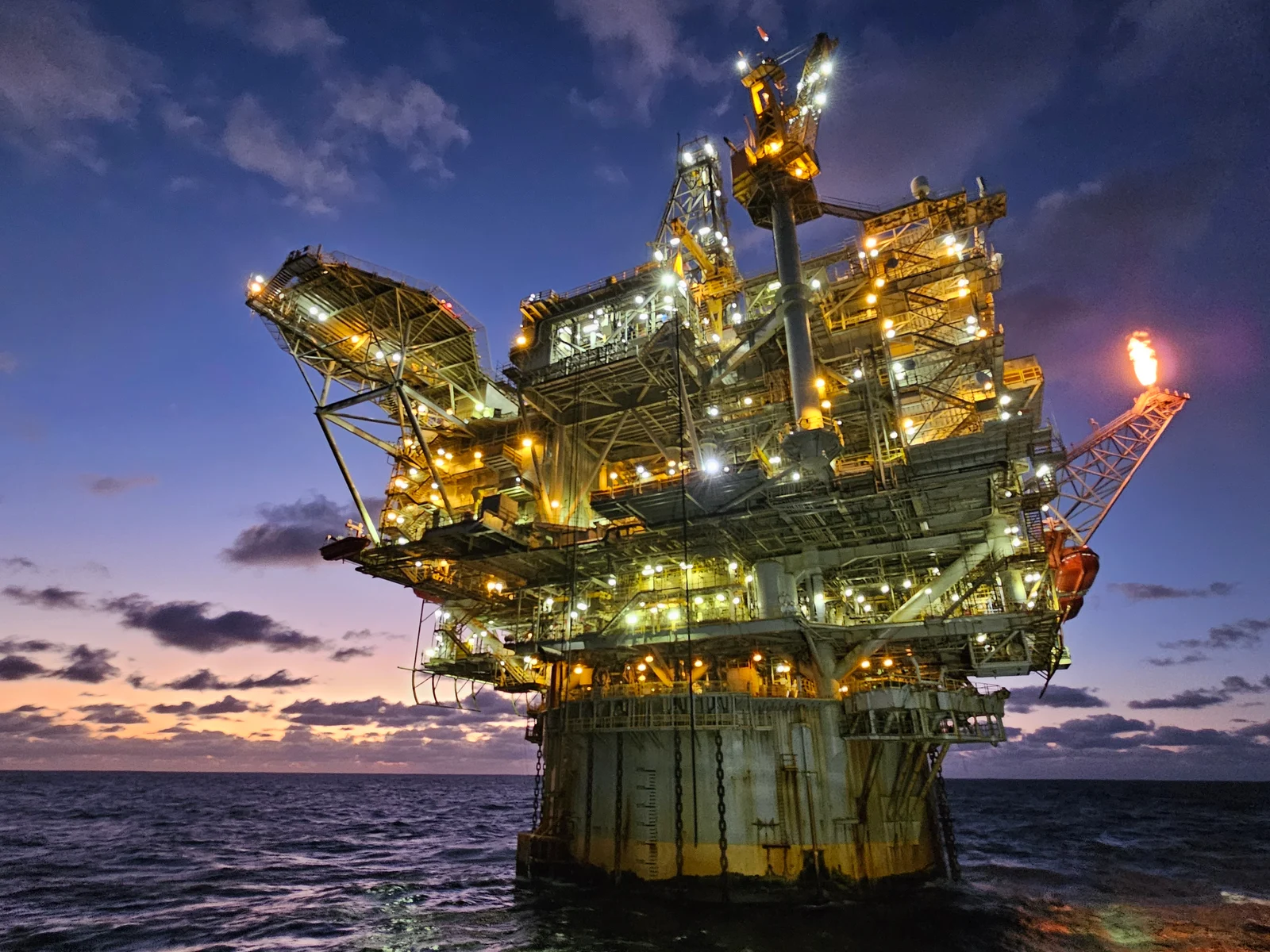 Holstein offshore oil platform illuminated at dusk in the Gulf of Mexico